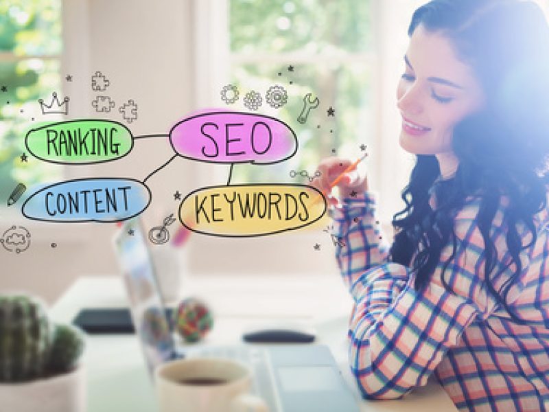 SEO concept with young woman holding a pencil